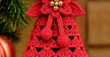 Red crochet Christmas bell ornament with a lace shell pattern, poinsettia flower, gold bead center, hanging loop, and bell.