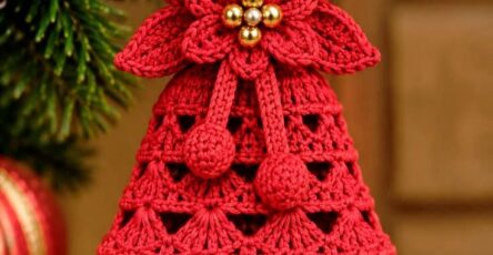 Red crochet Christmas bell ornament with a lace shell pattern, poinsettia flower, gold bead center, hanging loop, and bell.