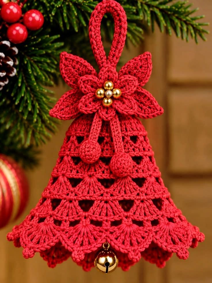 Red crochet Christmas bell ornament with a lace shell pattern, poinsettia flower, gold bead center, hanging loop, and bell.