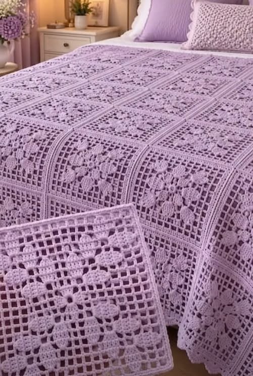 Lavender crochet bedspread made from floral granny squares with lacy grid borders, covering a bed in a softly decorated room.