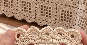 Close-up of a cream crochet square motif and a bedspread made from joined crochet lace squares.