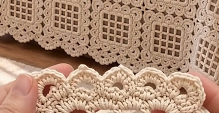 Close-up of a cream crochet square motif and a bedspread made from joined crochet lace squares.
