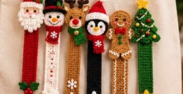 Six colorful crocheted Christmas character bookmarks, including Santa, snowman, reindeer, penguin, gingerbread, and a tree, displayed on a tote bag.