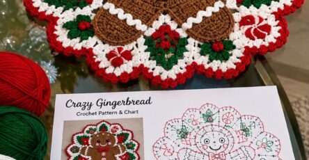 A crocheted gingerbread man doily centerpiece with scalloped holiday border, candy motifs, and holly leaves in red, white, green, and brown yarn.