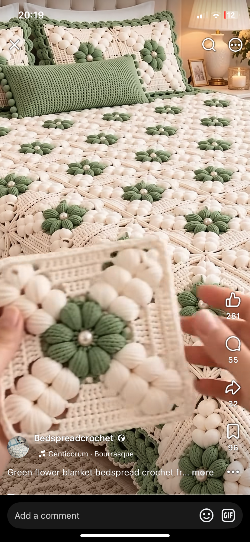 A crochet bedspread made from green and white granny squares featuring textured flower motifs.