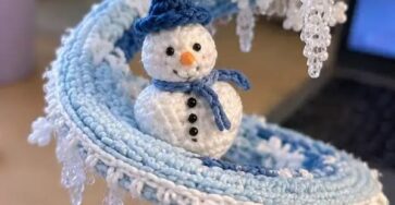Crochet spiral centerpiece decorated with snowmen, beaded icicle fringe, and snowflake motifs in blue and white.