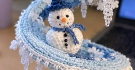 Crochet spiral centerpiece decorated with snowmen, beaded icicle fringe, and snowflake motifs in blue and white.