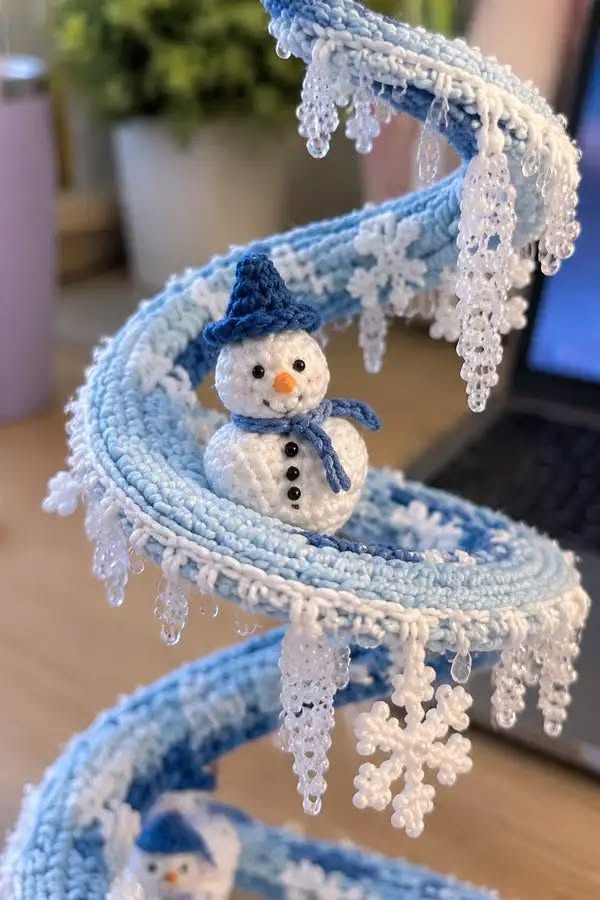 Crochet spiral centerpiece decorated with snowmen, beaded icicle fringe, and snowflake motifs in blue and white.