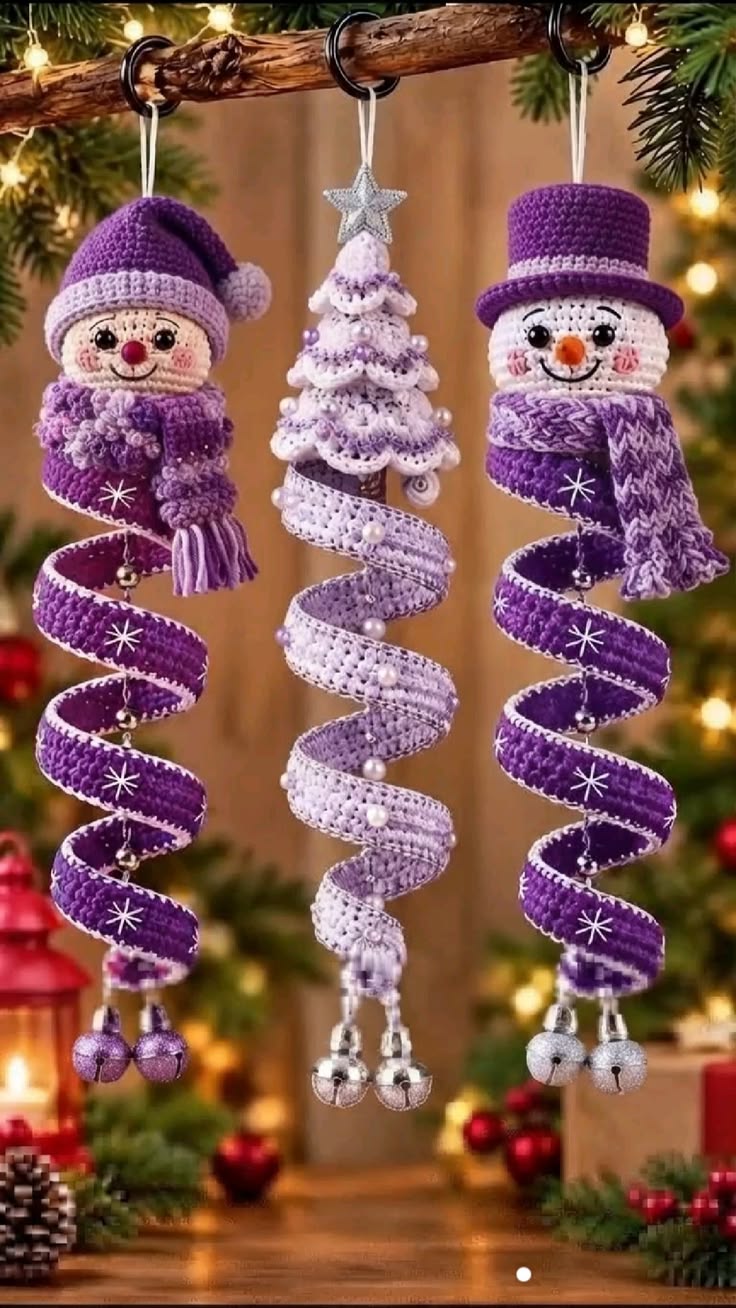 Three crochet Christmas ornaments: two purple-accented spiral snowmen and one spiral Christmas tree, all hanging as festive decorations.