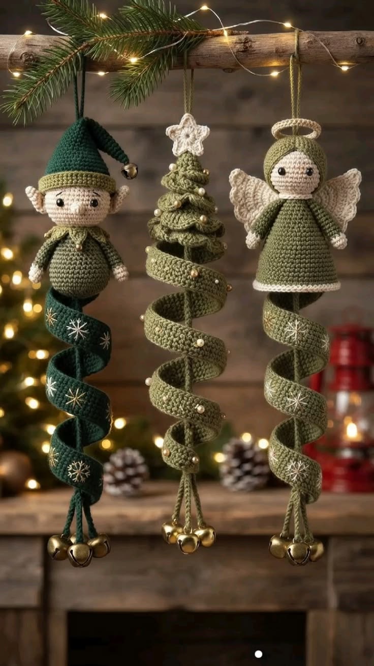 Three green crochet Christmas tree ornaments: an elf, a tree, and an angel with spiral bases and bells, hanging on a festive branch.