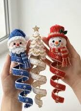 Three spiral crochet Christmas ornaments: a blue Santa, a white and gold Christmas tree, and a red snowman, each held by hand.