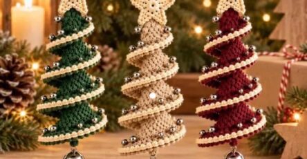 Three spiral crochet Christmas tree ornaments in green, beige, and red with beaded garlands, star tops, and bells hanging at the bottom.