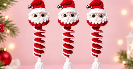 Three crochet Santa Claus ornaments with spiral red and white bodies, each with a Santa head and hat, hanging against a pink background.
