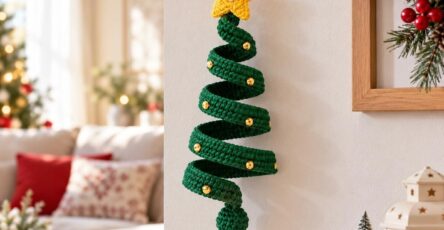 A crocheted green spiral Christmas tree wall hanging with a yellow star and gold button decorations.