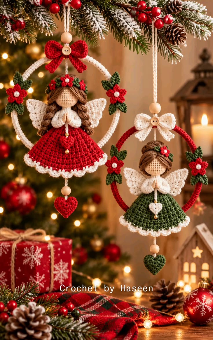 Two crocheted angel Christmas ornaments, one in red and one in green, hanging inside circular hoops and decorated with flowers, bows, and hearts.