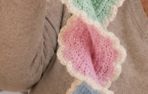 A spiral garland made of pastel crochet butterfly motifs with lacy white edging.