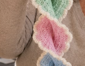 A spiral garland made of pastel crochet butterfly motifs with lacy white edging.
