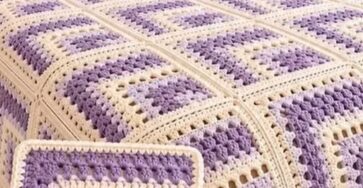 Lavender and cream log cabin granny square crochet blanket on a bed with matching pillows in a cozy bedroom.