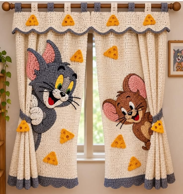 Hand-crocheted curtains with a cartoon cat, mouse, and yellow cheese applique designs, suitable for a playful kids' room decor.