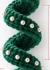 A crochet ornament shaped like a spiral Christmas tree, decorated with beads, a metallic star at the top, and a bell at the bottom.