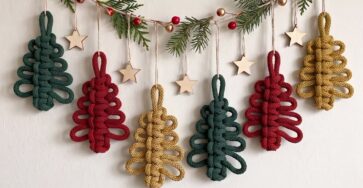 Crochet garland of stylized Christmas trees with large horizontal loops in green, red, and gold, decorated with natural twine and faux greenery.