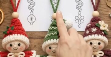 Three spiral crochet Christmas elf ornaments in red, green, and burgundy, with smiling faces, round hats, ruffled collars, and curly spiral bodies.