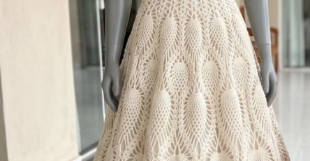 Strapless, full-length cream crochet gown with a textured fitted bodice and intricate pineapple lace skirt displayed on a mannequin.