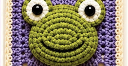 A 3D crochet granny square featuring a raised green frog face with large eyes, set against a purple background and cream border.