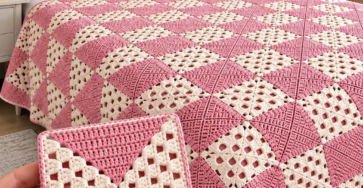 A pink and cream crochet quilt and pillows on a bed, made from modern granny squares, with a close-up of one square in the foreground.
