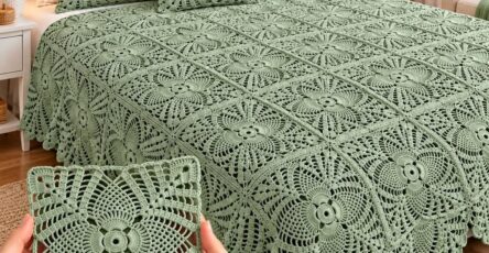 Light sage green crocheted bedspread with matching pillows, featuring intricate lacy square motifs in a bright and elegant bedroom.