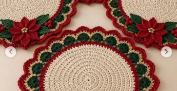 Round crochet placemat with cream center, scalloped red, green, and gold border, and a red poinsettia floral applique with green leaves.